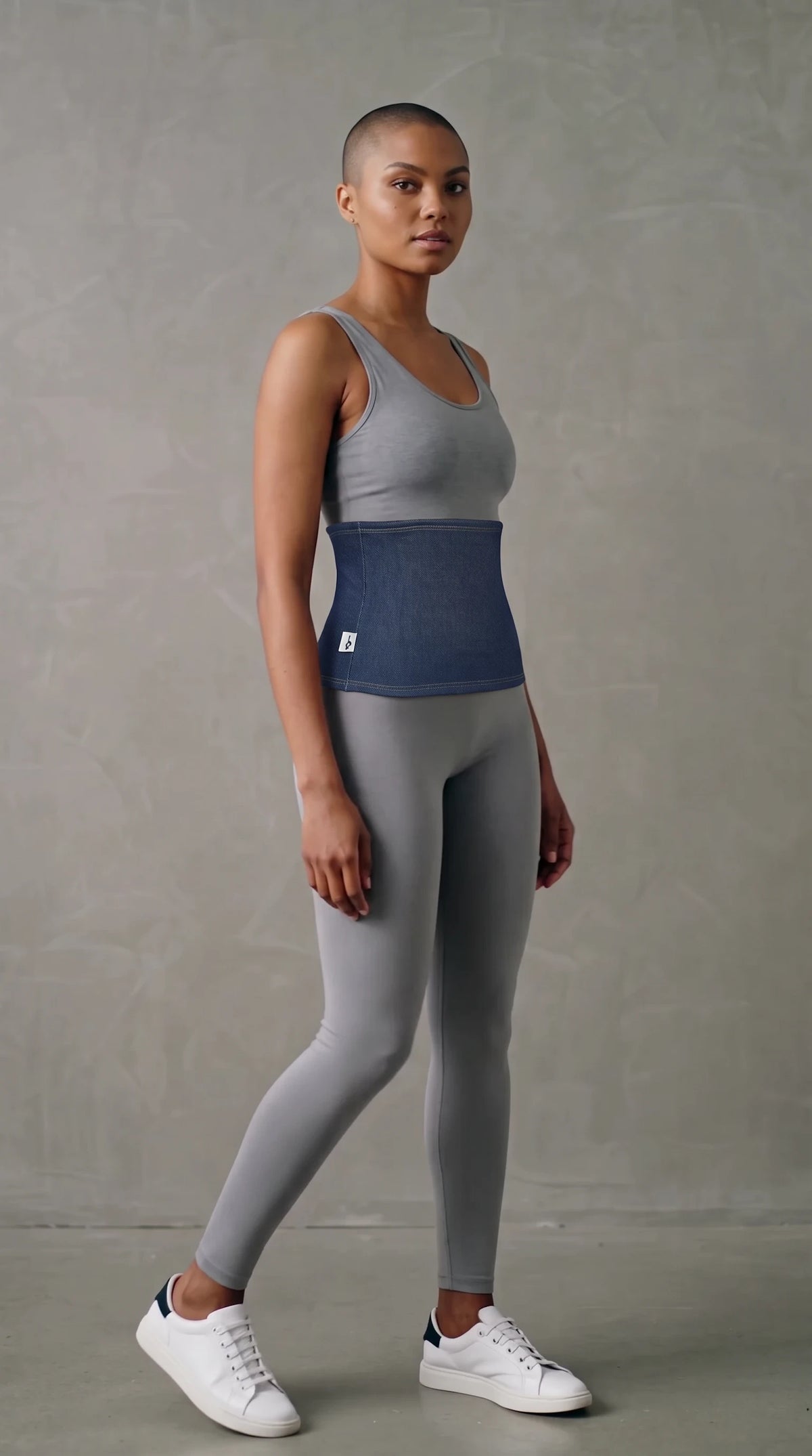 Model wearing a Fly and Fit dark blue denim-look fleece haramaki core warmer over a grey athletic set.