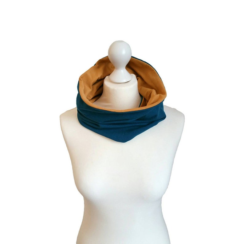 Mannequin wearing a petrol and mustard scarf on a white background