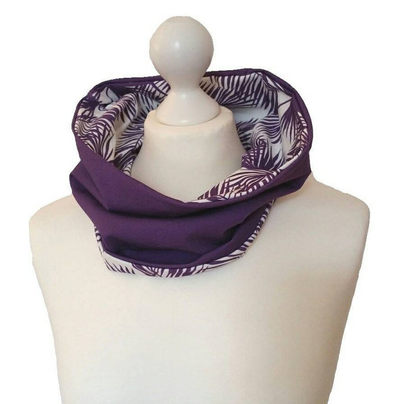 Purple scarf with white leaf pattern on a mannequin bust against a white background