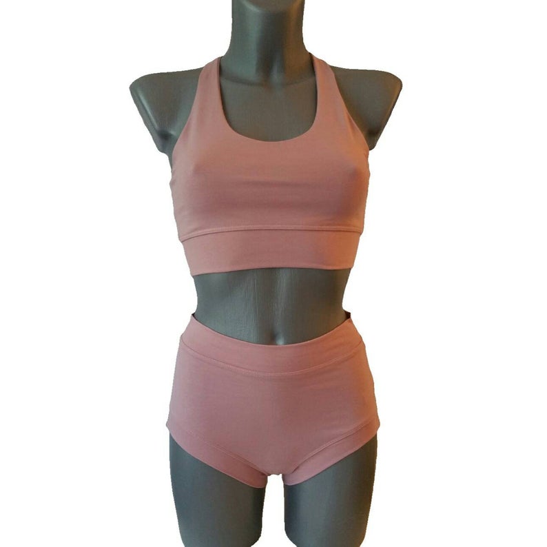 Pink sports bra and shorts set on a mannequin against a white background