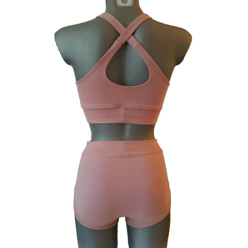 Pink sports bra and shorts set on a mannequin against a white background