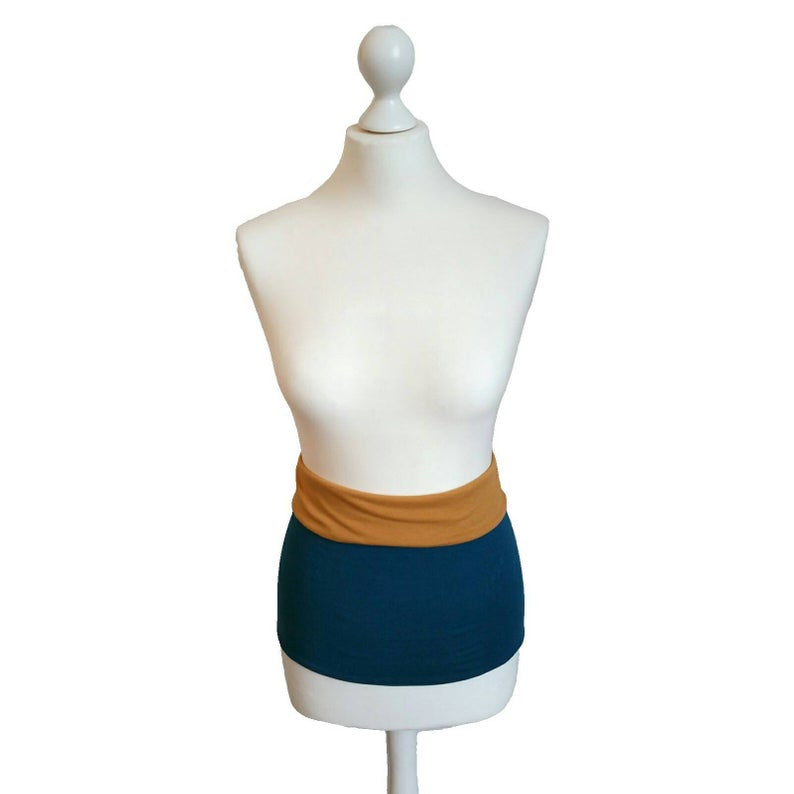 Mannequin wearing a petrol and mustard core warmer on a white background