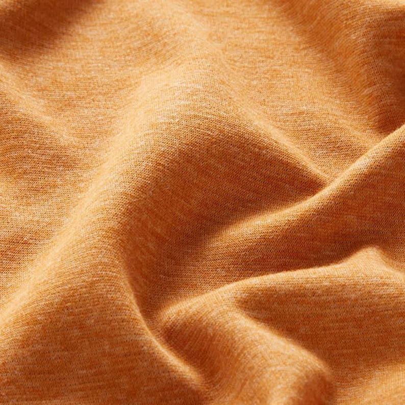 Close-up of Fly and Fit curry yellow Alpine fleece fabric showing the soft, textured thermal material.