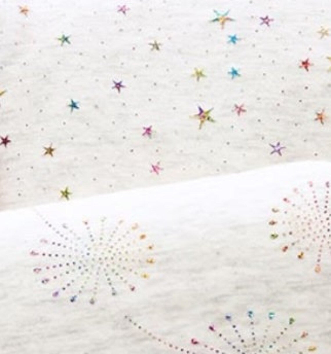 Fly and Fit Alpine fleece core warmer featuring a white fabric with colorful glitter star and dandelion print.