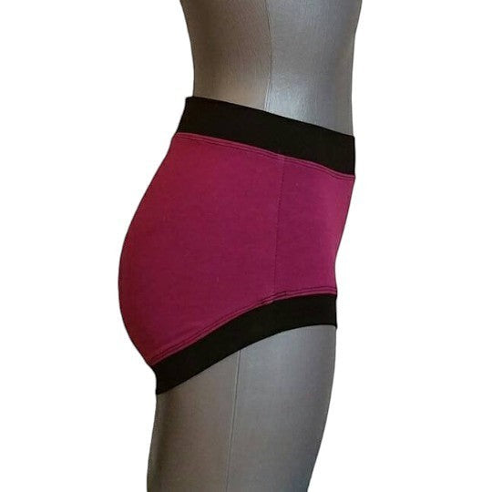 Fly and Fit Free-Flow contrast shorts in magenta cotton with black bands, side view on a mannequin.
