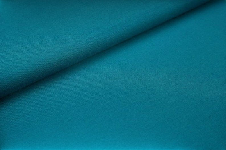 Fly and Fit reversible core warmer fabric in deep petrol blue, showing the soft, stretchy Oeko-Tex cotton texture.