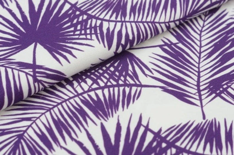 Fly and Fit reversible core warmer fabric featuring a purple tropical leaf print on a crisp white background