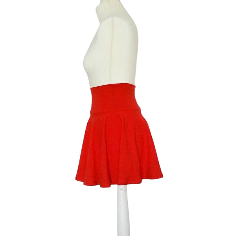 Fly and Fit red cotton skater skirt with a high-rise, elastic-free waistband on a mannequin, side view.